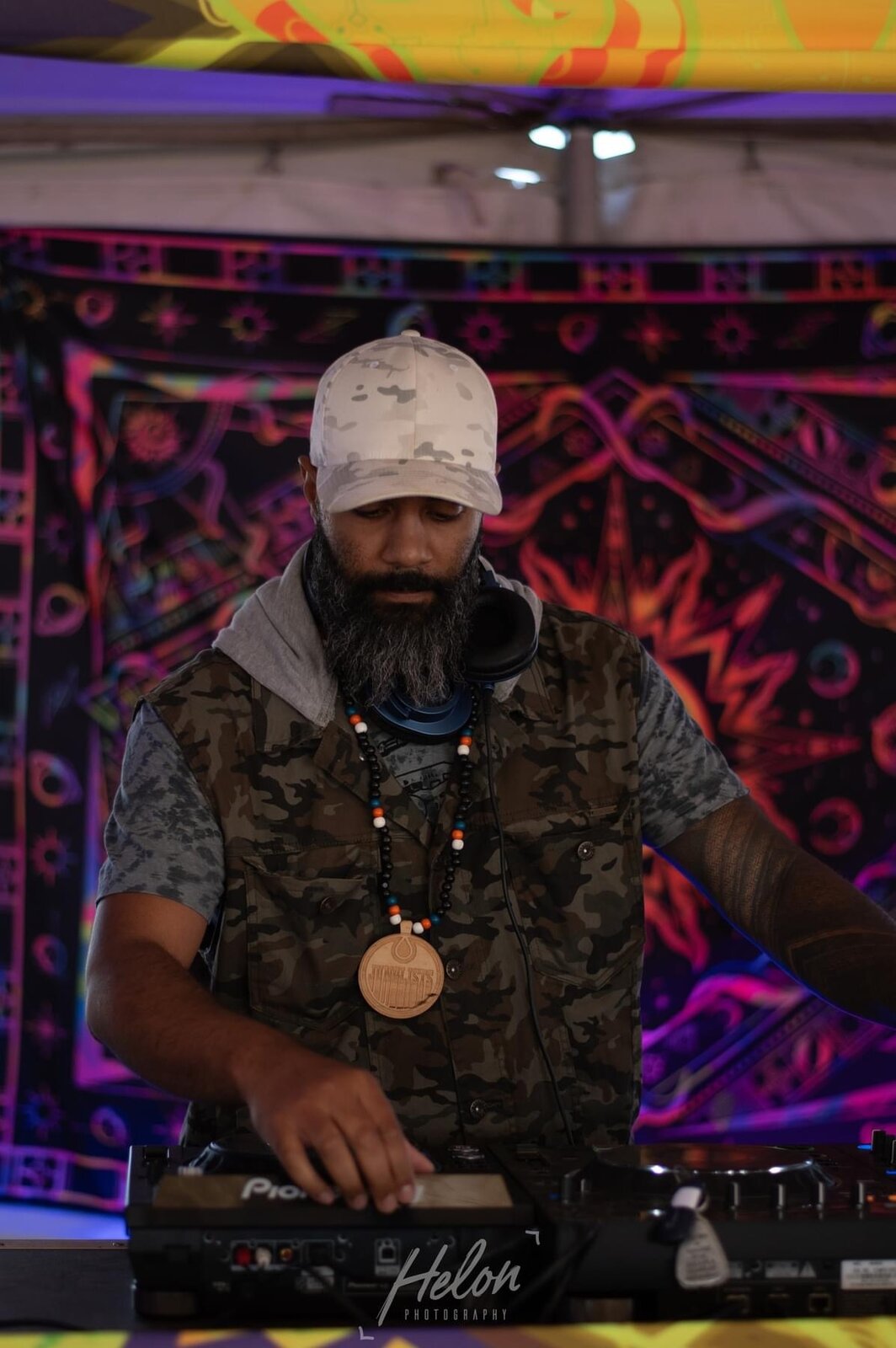 JT.dnb performing in front of a colorful backdrop